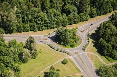 Aerial view of two cars approaching a roundabout